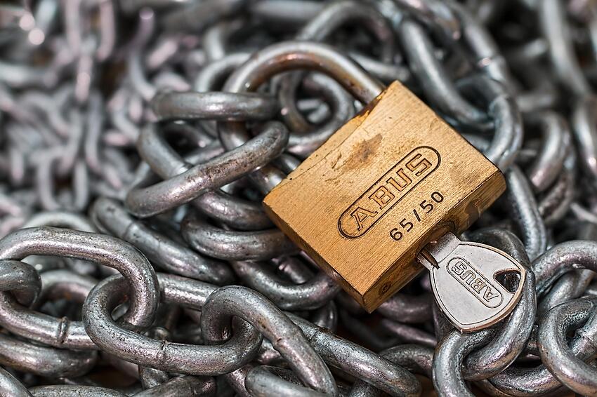 A padlock and chain on a gate, seen close up